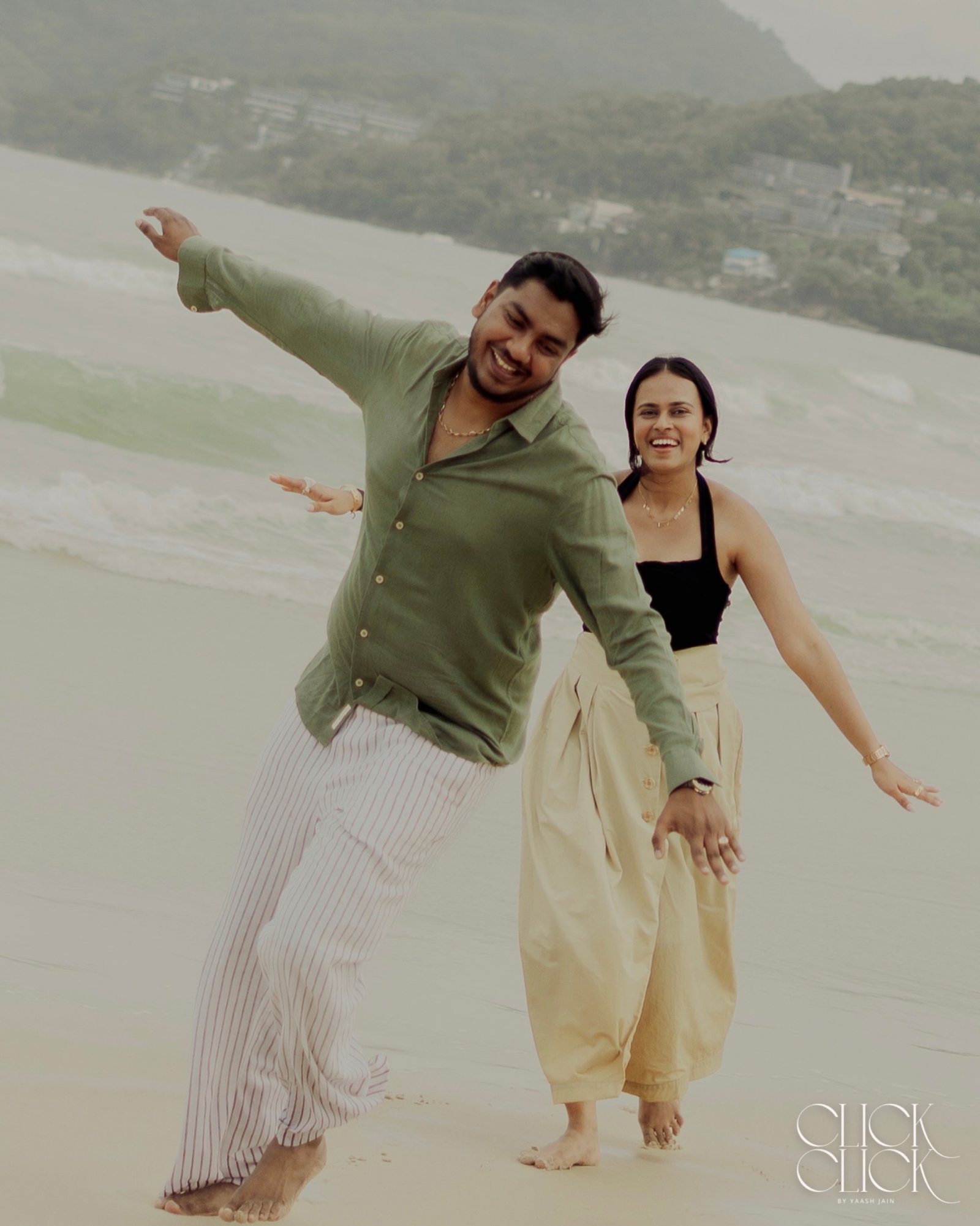A joyful couple running together on a beach