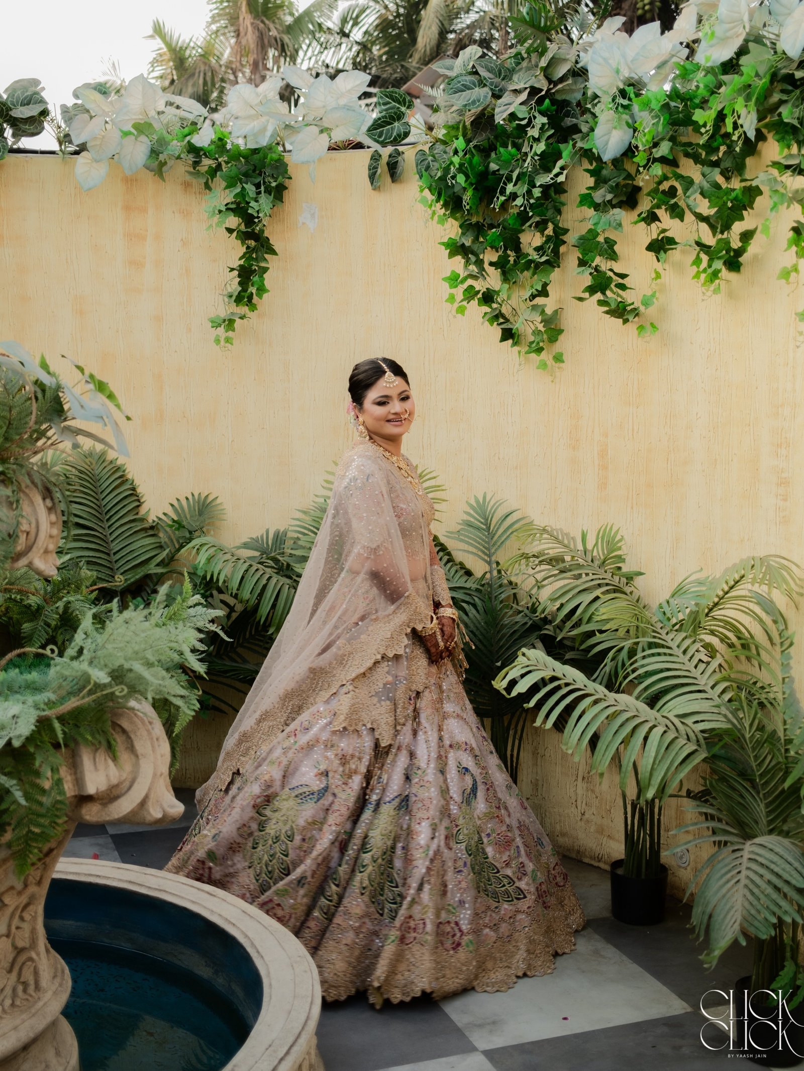 A bride walking through a garden in her embroidered lehenga