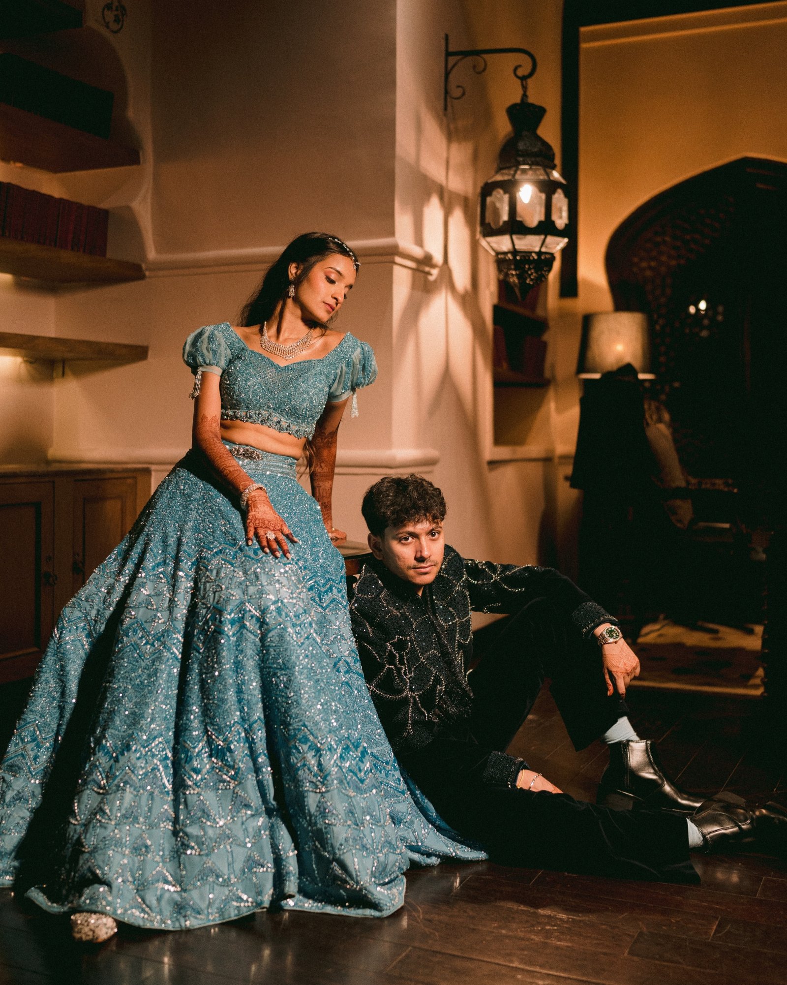 A couple in blue and black evening attire posing together